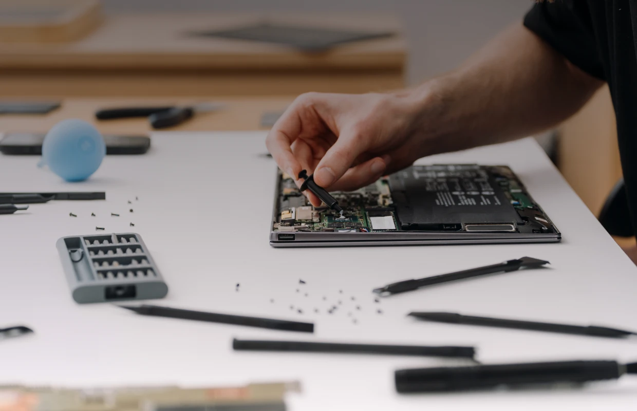Hand fixing a laptop motherboard